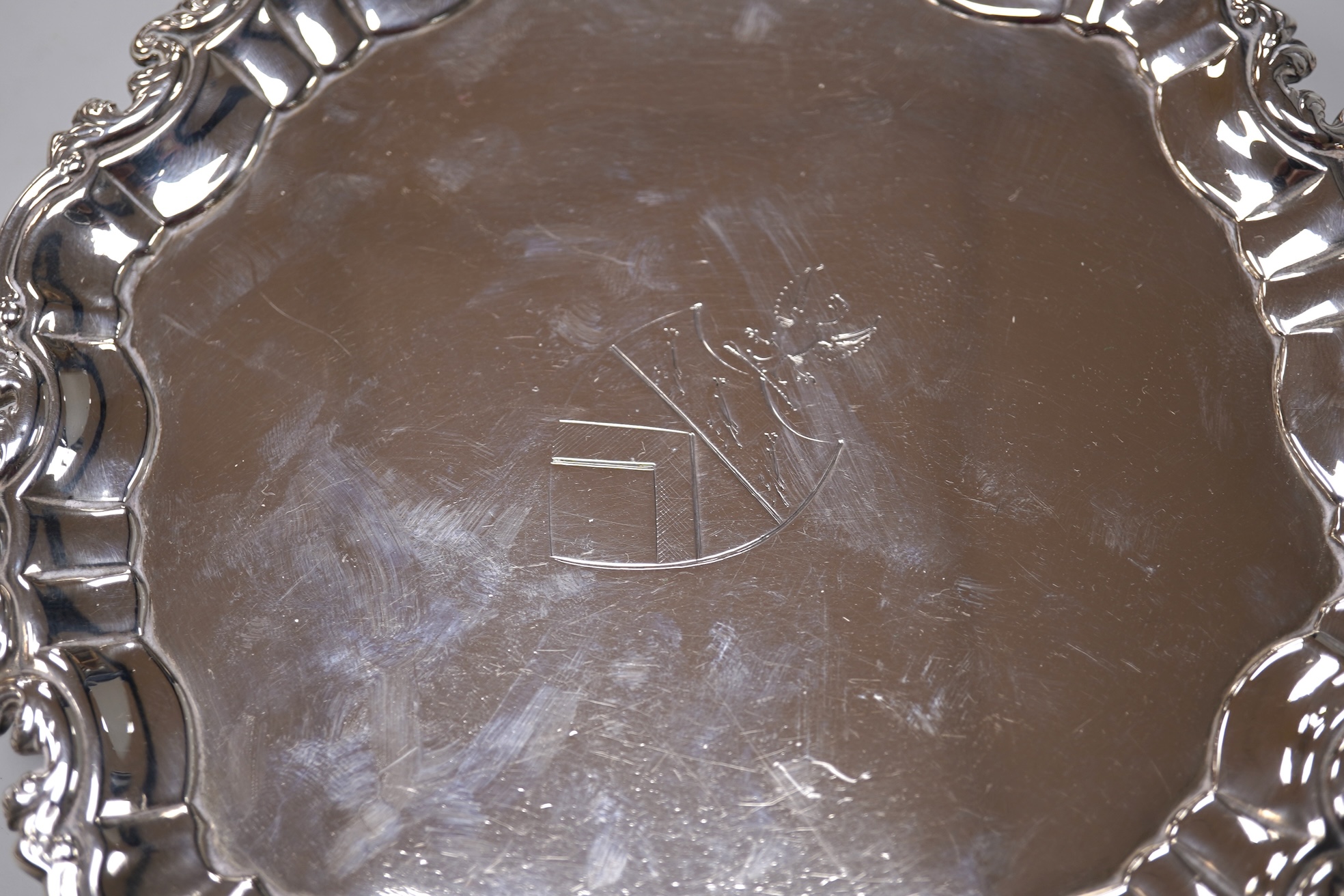 A George II silver card waiter, (with Howard Tripp crest?), of shaped circular form, on three scroll feet, maker's mark rubbed, London, 1740, 17.9cm, 9.4oz.